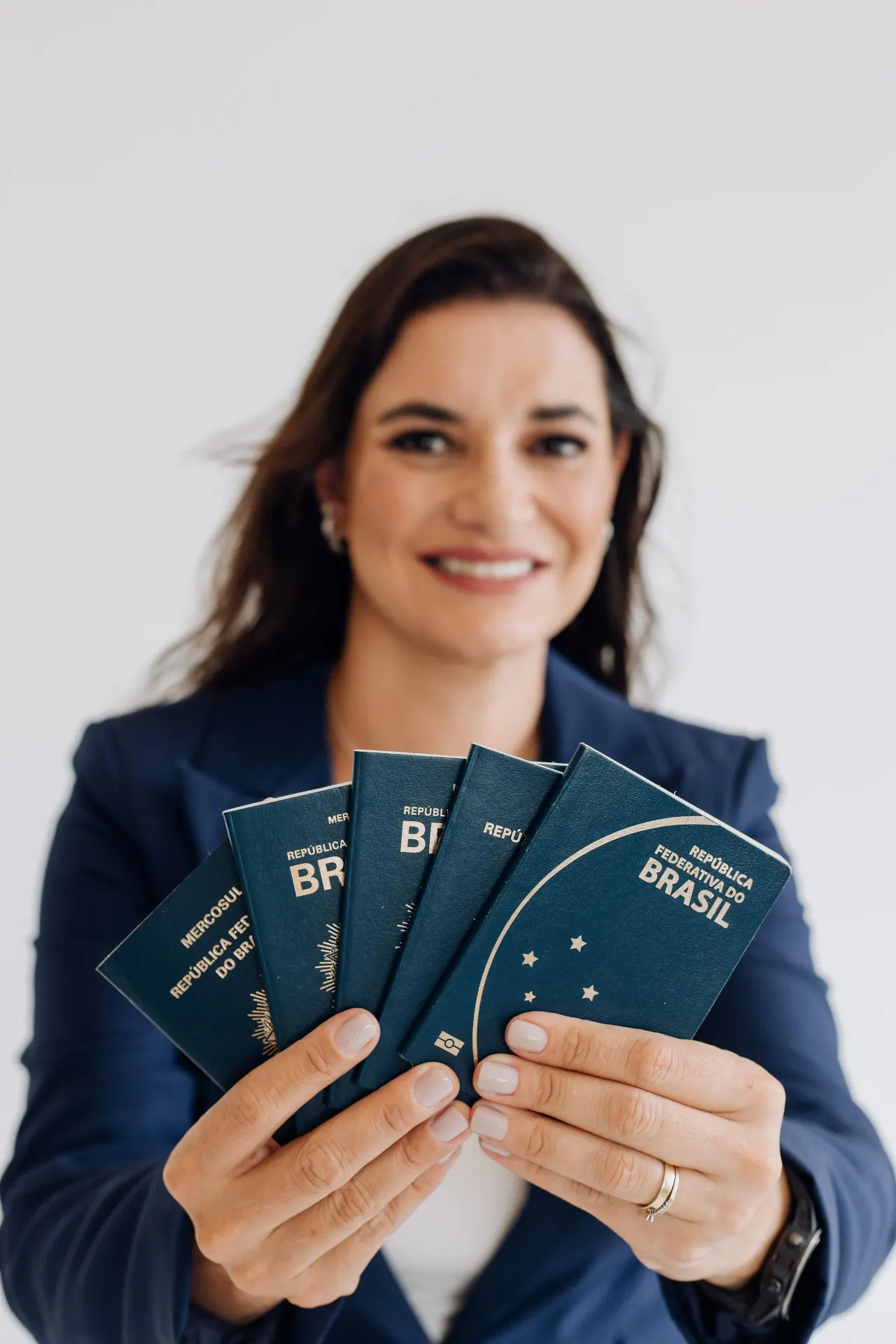 Giovanna, especialista da GI Intercâmbio, segurando passaportes brasileiros